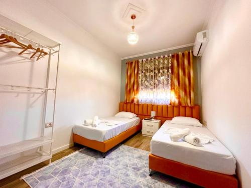 um quarto com duas camas e uma janela em The Luxe Apartments em Gjirokastër