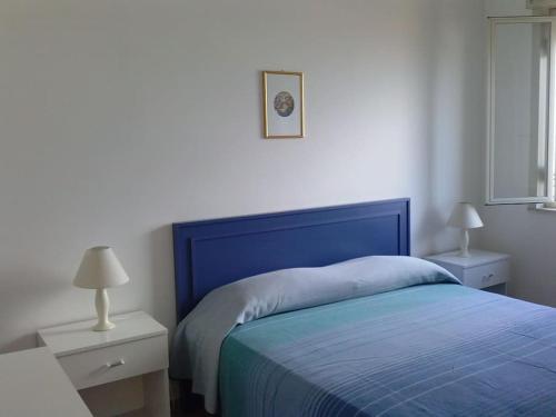 a bedroom with a blue bed and two night stands at Casa Fenice in Marinella di Selinunte