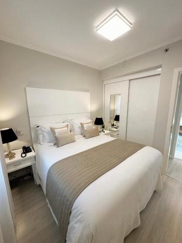 um quarto com uma grande cama branca e uma janela em Sao Paulo Ibirapuera Privilege - Suite Deluxe em São Paulo