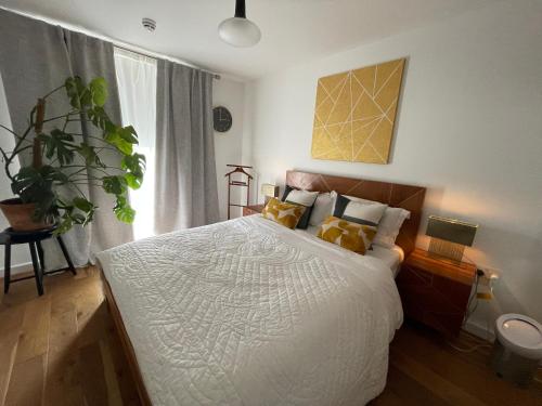 a bedroom with a large white bed with yellow pillows at Peloton Organic Health Apartment in Angel, Old Street, Islington in London