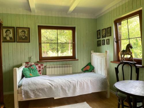 a bedroom with a bed and a table and a window at Dom Pod Dobrym Drzewem in Inowłódz