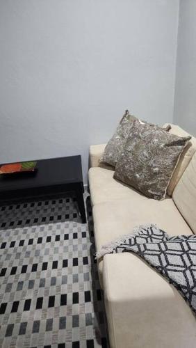 a white couch with two pillows on it in a room at Tranquility on St James in Johannesburg
