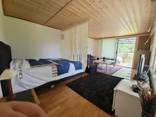 a bedroom with a bed and a living room at Paradiset in Kulltorp