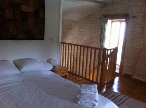 a bedroom with a bed and a staircase with a window at La Petite Maison in Crézières