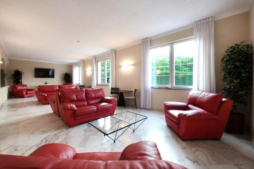 a living room with red couches and a table at Hotel Internazionale in Domodossola