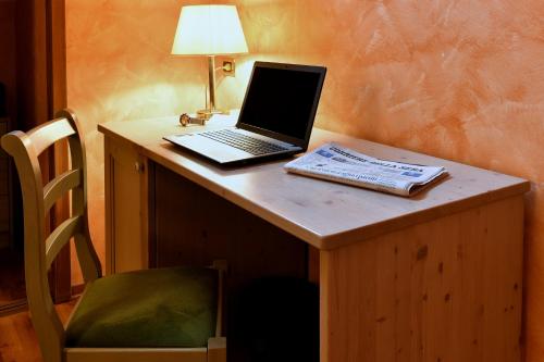 a laptop computer sitting on top of a wooden desk at Hotel Internazionale in Domodossola