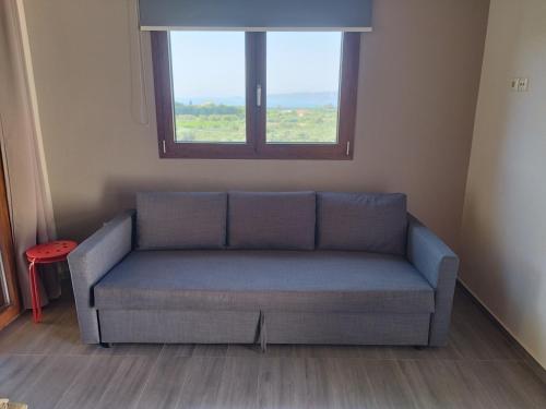 a couch in a living room with a window at Mary's Panorama Houses in Gialova