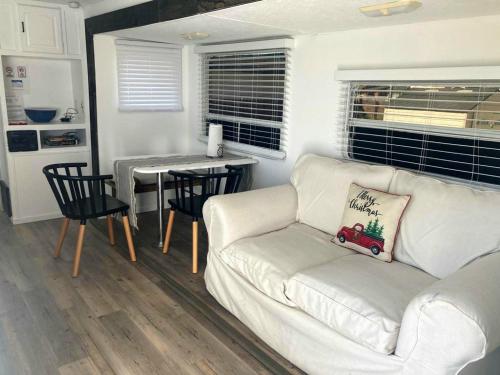 Comfy stay in private 2beds, 1bath kitchen RV في إسكونديدو: غرفة معيشة مع أريكة بيضاء وطاولة