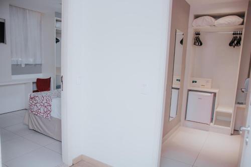 a white room with a bed and a mirror at Rede Andrade Lapa in Rio de Janeiro