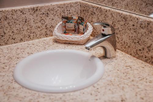 a bathroom counter with a white sink and a faucet at Rede Andrade Lapa in Rio de Janeiro