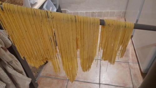 a bunch of yellow pasta hanging from a pole at La Parenthèse, chambres d'hôtes in Rochegude-Drome
