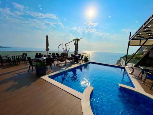 a swimming pool on a deck with the ocean in the background at Apart Lux Beciragic in Dobra Voda