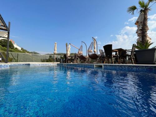 a swimming pool with chairs and a swimming pool at Apart Lux Beciragic in Dobra Voda