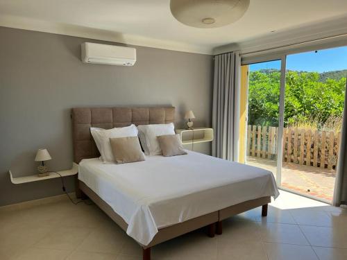 une chambre avec un grand lit blanc et un balcon dans l'établissement La Villa Diane, à Saint-Peïre-sur-Mer