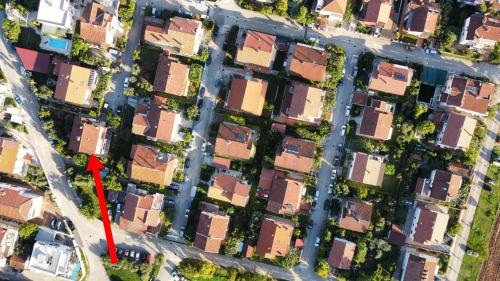an aerial view of houses in a suburb with a red arrow at Apartments Reinić in Novigrad Istria