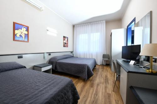 a hotel room with two beds and a television at Hotel Internazionale in Domodossola