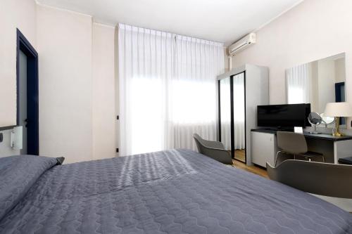 a bedroom with a bed and a desk and a television at Hotel Internazionale in Domodossola