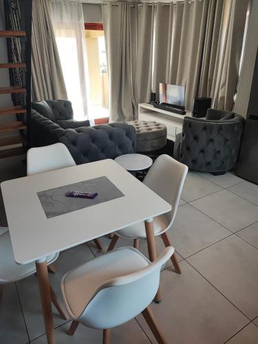 a living room with a white table and chairs at Kyalami Boulevard Estate, Kyalami Hills ext 10 Robin Road Midrand in Midrand