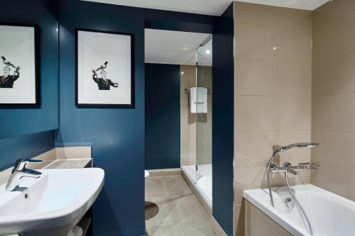 a bathroom with a sink and a shower and a tub at Portsmouth Marriott Hotel in Portsmouth