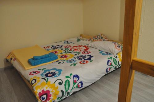 uma cama num quarto com um cobertor estampado de flores em CHEZ YAYA Bogumiła Szeląg em Zalasowa