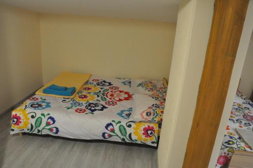 a small bedroom with a bed with a colorful blanket at CHEZ YAYA Bogumiła Szeląg in Zalasowa