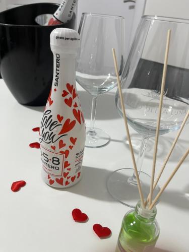 a bottle of wine next to two glasses and hearts at B&B Due Su Due Holiday in Vietri sul Mare