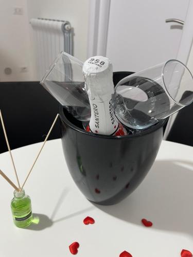 a bowl with a bottle and glasses on a table at B&B Due Su Due Holiday in Vietri sul Mare