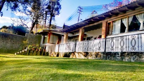 a house with a white fence and a yard at Don Polo casaboutique in Valle de Bravo