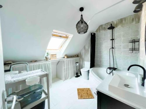 een badkamer met een bad, een wastafel en een bad bij Gîte Family pour les petits et pour les grands in Paimpol
