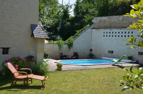 una piscina in un cortile con una sedia di Chambre Gargantua Le dolmen a Thizay