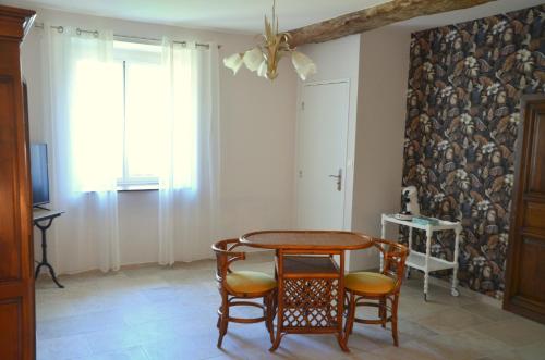 - une salle à manger avec une table et quatre chaises dans l'établissement Chambre Gargantua Le dolmen, à Thizay