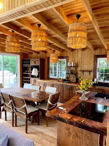 Il comprend une cuisine avec une table en bois, des chaises et des lustres. dans l'établissement Antalya Holiday Villa, à Dosemealti