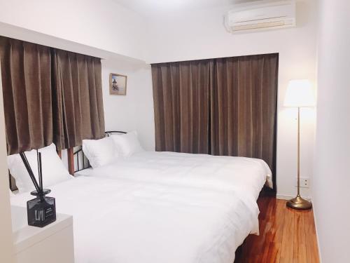 a bedroom with two white beds and a window at tokyo sky dream shinjuku in Tokyo
