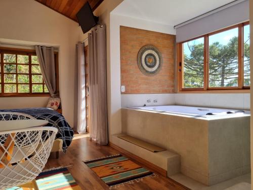 a large bathroom with a tub and a window at Pousada Reserva Nativida in Santo Antônio do Pinhal