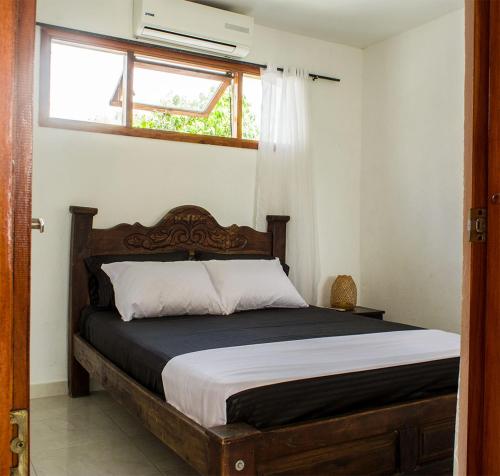 1 cama en un dormitorio con ventana y 1 cama sidx sidx sidx sidx en HOSTAL LA BOQUILLA, en Cartagena de Indias