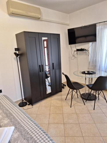 a bedroom with black doors and a table and chairs at Apartments Reinić in Novigrad Istria
