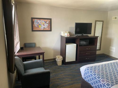 a hotel room with a bed and a tv and a chair at Econo Lodge in Mechanicsburg