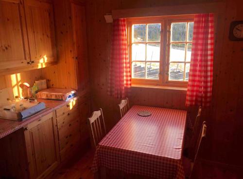 eine kleine Küche mit einem Tisch und einem Fenster in der Unterkunft Hytte på idyllisk seter in Fosset