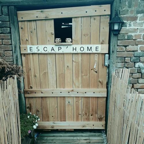 une porte en bois avec un panneau indiquant la maison esapa dans l'établissement Escap'Home - Appartement insolite avec enquête en autonomie - Escape game Locked, à Friville-Escarbotin