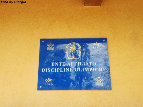 a sign on the side of a yellow wall at Agriturismo Andreis Alloggi in Illasi