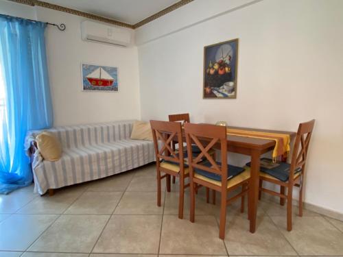 a living room with a table and chairs and a couch at Roula apartment in Nei Poroi