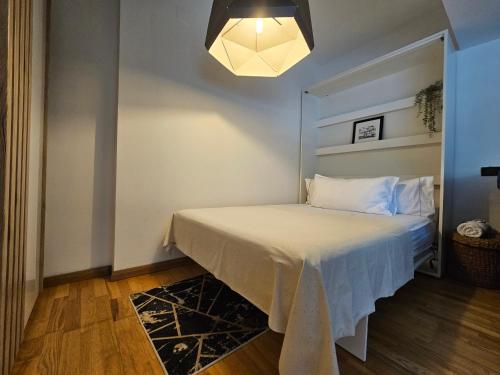 una piccola camera da letto con un letto con un copriletto bianco di RIVER VIEW - Izvor Studio a Bucarest