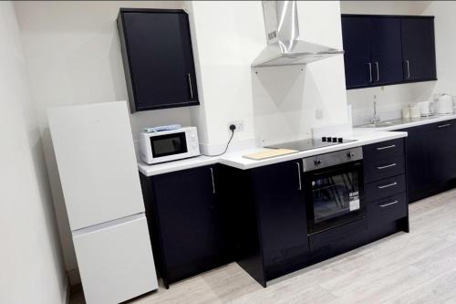 uma cozinha com um lavatório e um micro-ondas em West Lake District Comfort Stays in Maryport town centre em Maryport