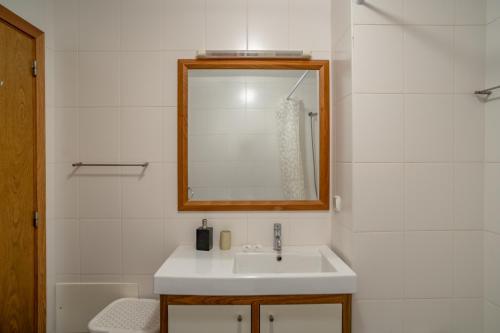 ein Badezimmer mit einem Waschbecken, einem Spiegel und einer Badewanne in der Unterkunft Front beach Apartment in Paul do mar 9 in Paul do Mar