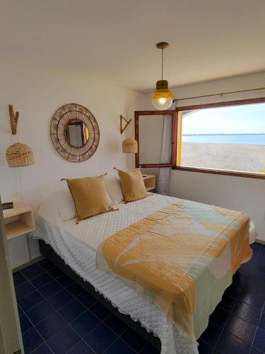 a bedroom with a bed with a view of the beach at Apartamentos Alborada in La Paloma