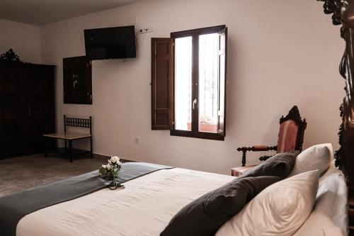 a bedroom with a large bed with a window at CASA DE LA SEÑORA in Palma del Río
