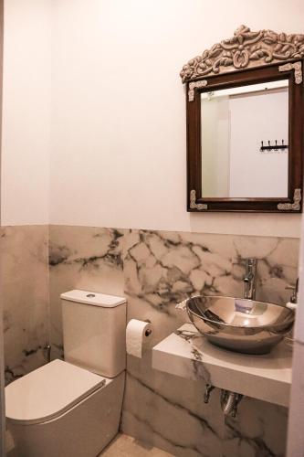a bathroom with a sink and a toilet and a mirror at CASA DE LA SEÑORA in Palma del Río