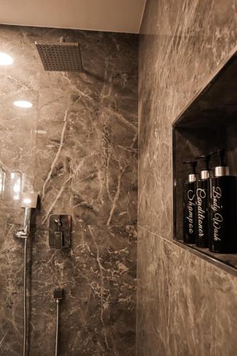 a bathroom with a shower with a marble wall at CASA DE LA SEÑORA in Palma del Río