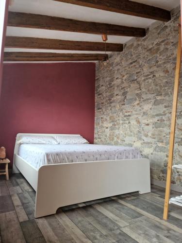 a bedroom with a white bed in a brick wall at Casa con terraza a 10min de la playa in Cullera