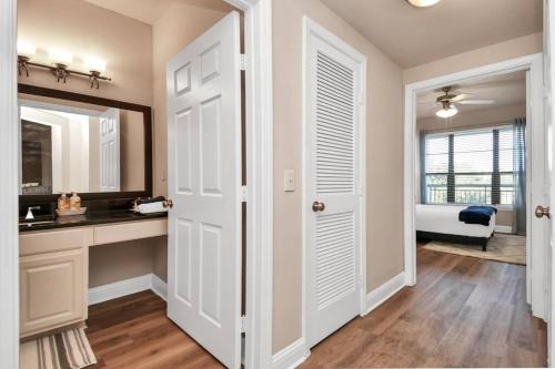 a bathroom with white doors and a sink and a mirror at Ultimate Retreat Near GALLERIA-POOL in Houston